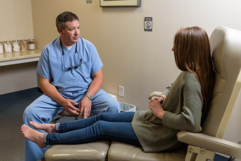 Podiatrist discussing treatment with female patient